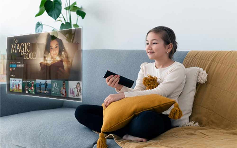 دختر بچه نشسته روی مبل در حال تماشای ویدیو