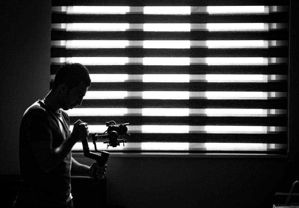 پسر فیلمبردار در حال تصویربرداری در مقابل پرده و پنجره
