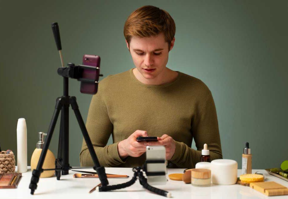 مردی نشسته جلوی دوربین در حال ساخت ویدیو معرفی محصول